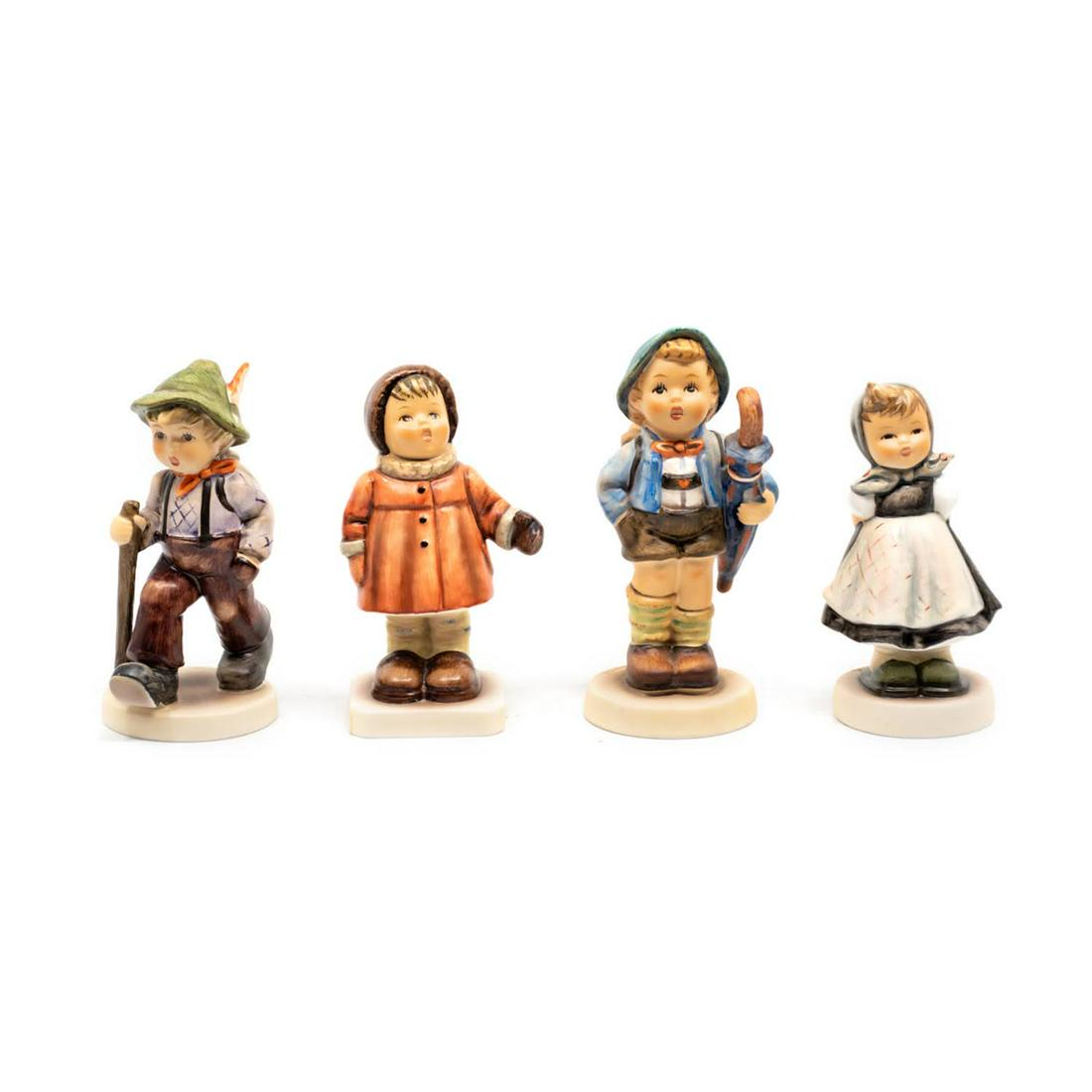 Group of 4 Goebel Hummels including Grandpa's Boy 562: Goebel Hummel #562 Grandpa's Boy TMK 7 features a boy walking with a stick and hiking boots while carrying a backpack, #476 Winter Song TMK 7 features a girl singing in a winter coat and mittens, #198
