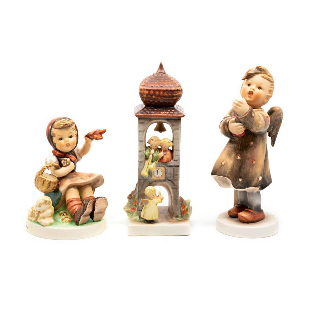 Group of 3 Goebel Hummels including Candlelight 192: Goebel Hummel #65 Farewell TMK 7 features a seated girl with a basket waving farewell, #163 Whitsuntide TMK 2 features two angels in a bell tower, playing trumpets for the third angel on the ground, a