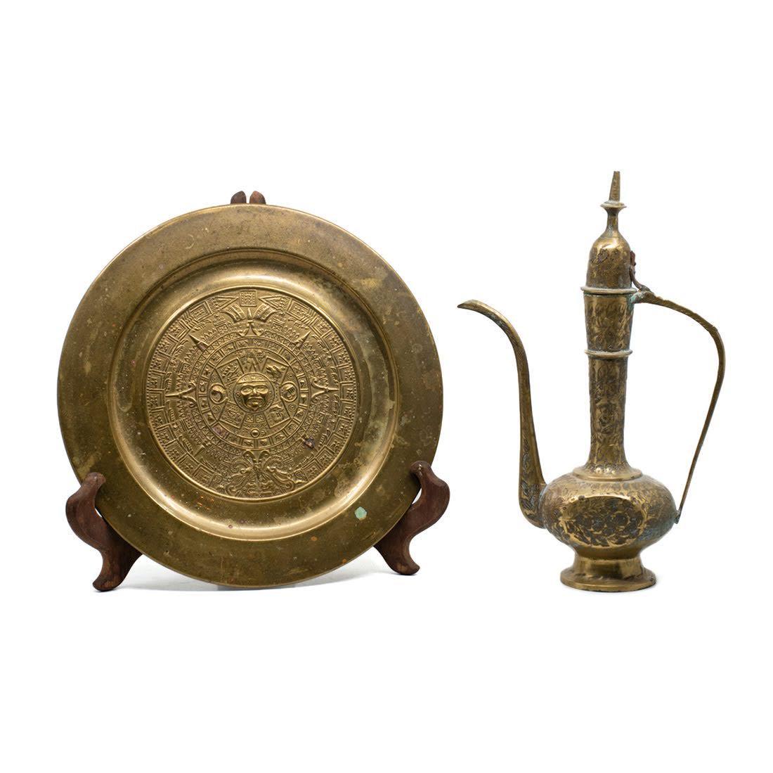 Mexican Mayan Calendar Brass Tray and Indian Brass: A group of two including a Mexican pressed brass decorative tray with Mayan calendar motif and an Indian brass ewer with leaf motif and lid. The plate is unmarked with hanging loop on back. The ewer i