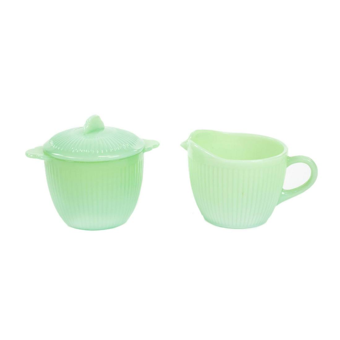 Set of 2 Fire-King Jadeite Cream and Sugar Bowls: A set of 2 Fire-King jadeite creamer and lidded sugar bowls in a light green jade with ribbed textures. Both marked on the underside.