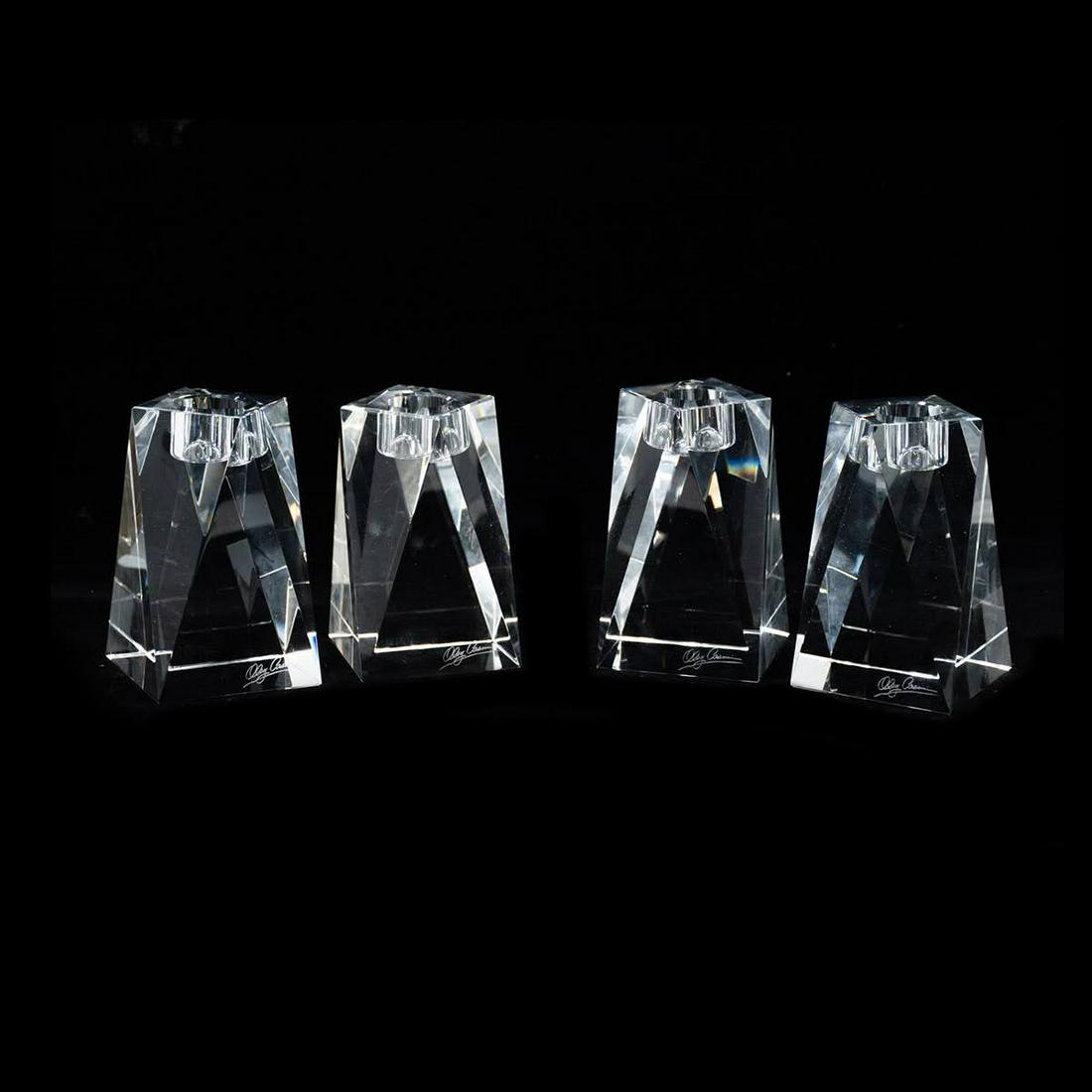 Set of 4 Oleg Cassini Brigitte Crystal Candle Holders: A set of four, two matching pairs, Oleg Cassini Brigitte crystal candle holders having a square cut, twist shape and round incised top for holding a candle. Signed.