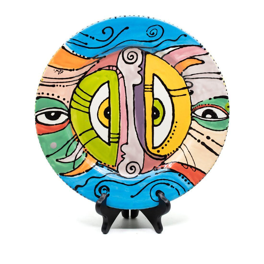 Clayton M for Practically Pikasso Charger Plate: A mid-century style charger plate painted by artist Clayton M. How for Practically Pikasso. Features an abstracted face in bright colors. Marked on front and back.