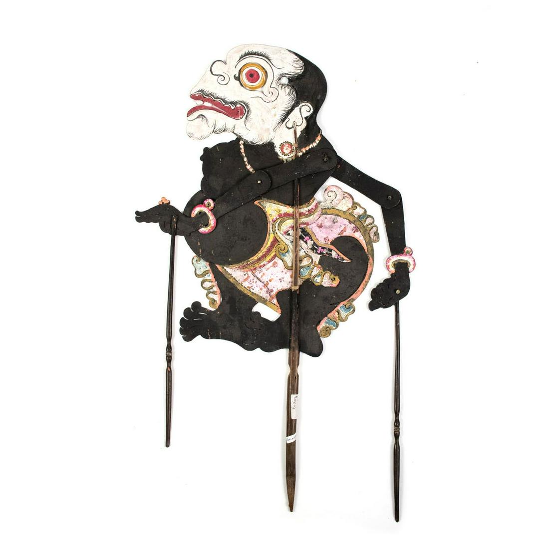 Indonesian Wayang Kulit Bagong Shadow Puppet: An Indonesian Wayang Kulit flat puppet (1940) intricately hand painted on leather hide. The character Bagong is depicted with a black body and white face. He is one of the clown characters of the adop