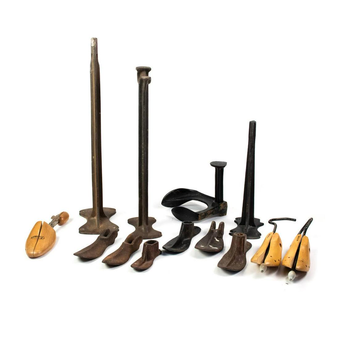 Grouping of Antique Wooden and Iron Cobbler Shoe Molds: A grouping of antique wooden and cast iron cobbler shoe molds including multiple shoe horns.
