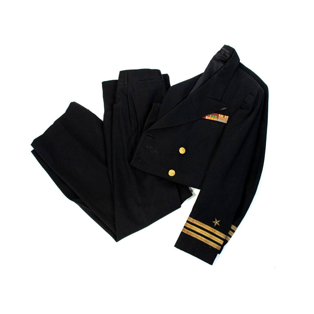 Service Dress Blues Uniform Suit Jacket and Pants: A vintage Service Dress Blues unifrom belonging to Commander Louis C. McConnel. Includes a suit jacket and pants in navy blue, adorned with colored patches and metals. Marked.