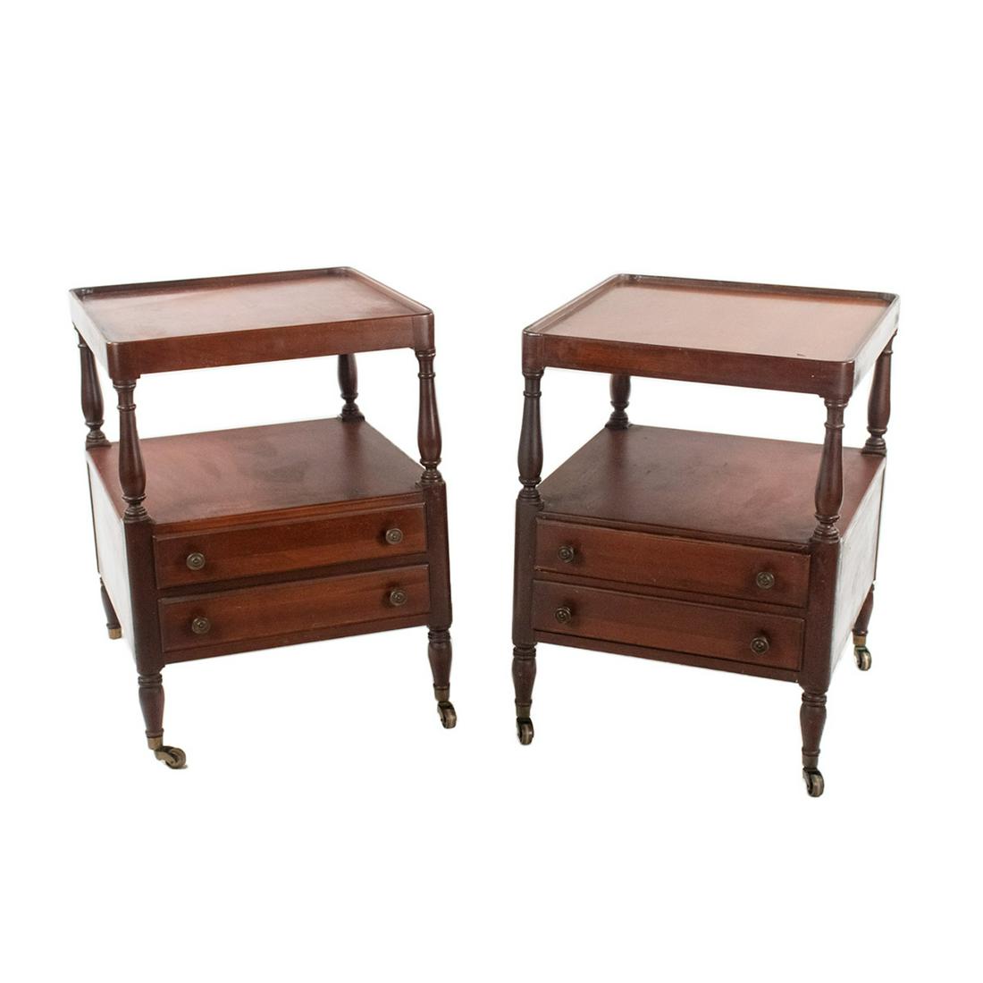 Pair of Regency Style Two Tier Side Tables: Pair of Regency style two tier side or end tables having lower shelf tier and two drawers with turned column supports and four turned legs with casters. Drawers feature bronze finish medallion pulls.