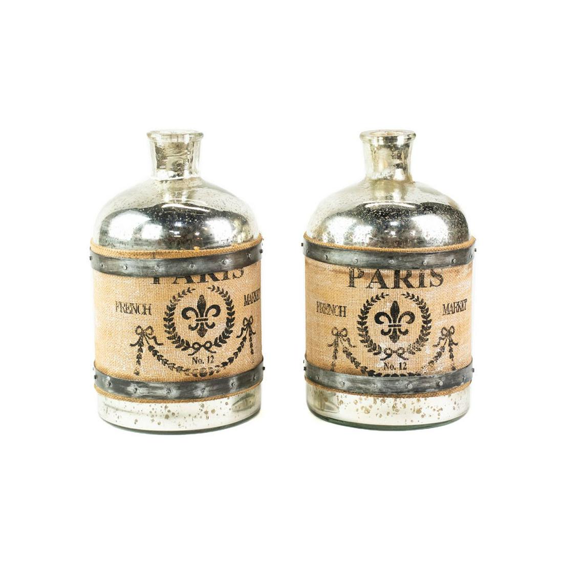 Pair of French-Inspired Mercury Glass Jugs: A pair of French-inspired mercury glass jugs decorated with printed canvas wrap-arounds bound by metal straps. Made in India.