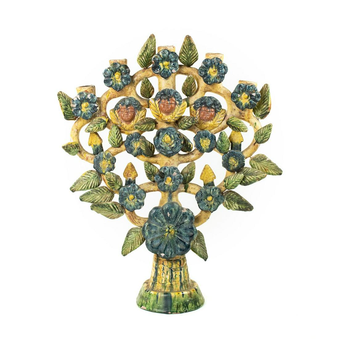 Mexican Folk Art Hand Painted Tree of Life Candelabra: A vintage Mexican Folk Art hand painted 'Tree of Life' ceramic or clay candelabra having three cherub faces with various flowers and leaves in blue and green hand painted and dyed colors. Extremely fr