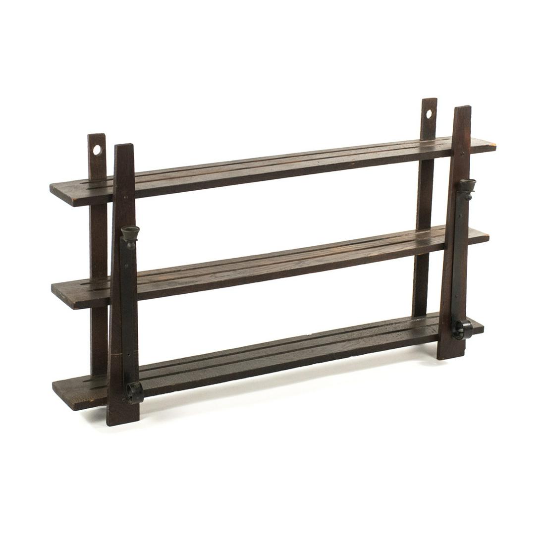Arts and Crafts Wood and Iron Wall Mount Plate Rack: An early 20th Century Arts and Crafts period wood with iron candle cup mounts wall plate rack having three shelves that are joined with tapered wood uprights and minimal scrolled candle mounts.