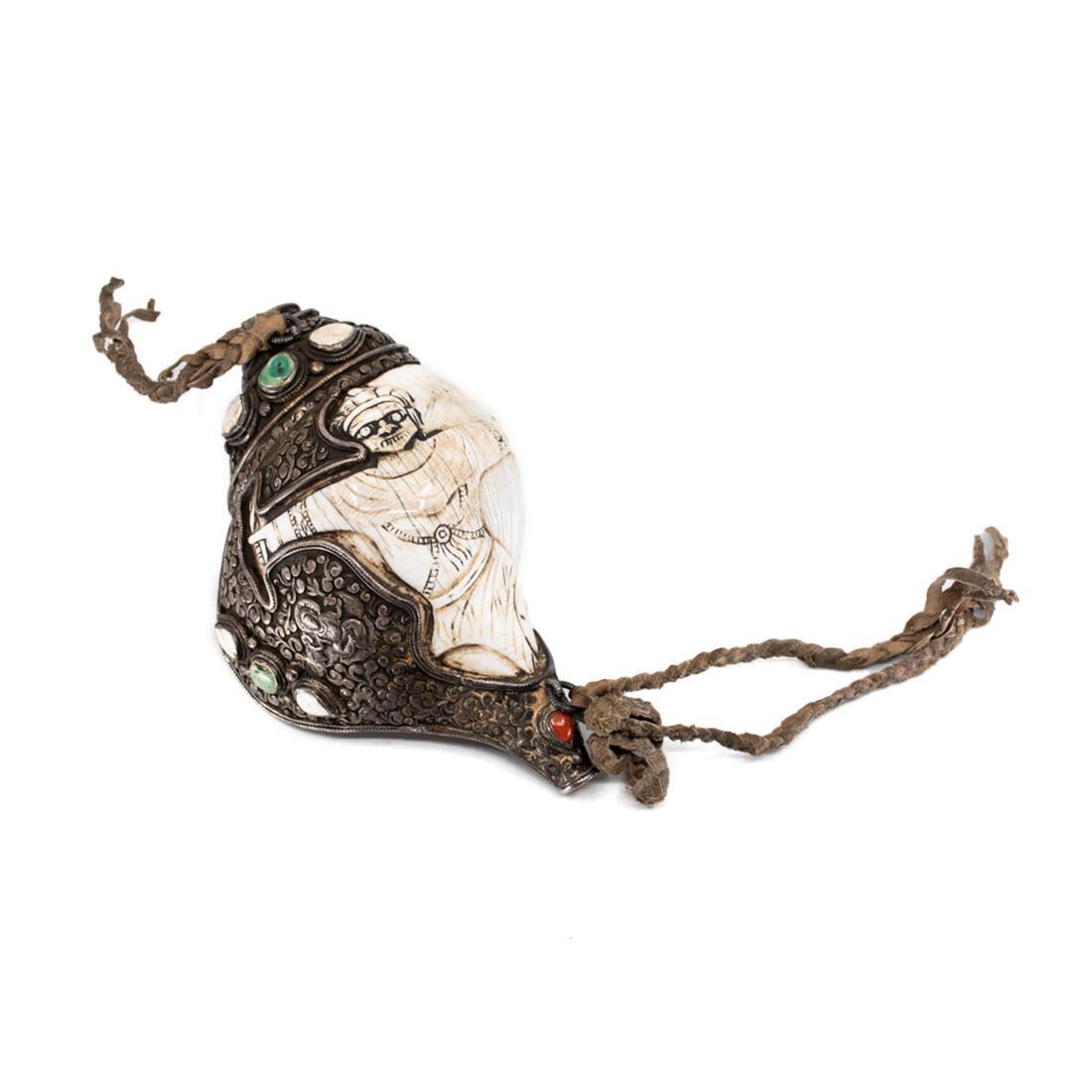 19th C. Tibet Sankha Sterling Silver Conch Horn: A Tibetan Shankha monastery ritual horn (19th Century) heavily carved and embellished conch shell with deeply hand tooled sterling silver depicting various Buddhist symbol and scrollwork with inset st