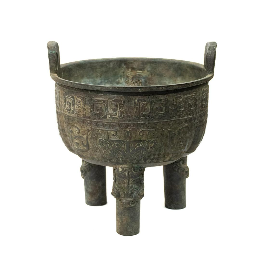Late Ming Chinese Bronze Ding Ritual Vessel: A late Ming Dynasty antique Chinese bronze Ding ritual vessel having tripod base and two handles on the rim. It features several embossed motifs including zoomorphic face and an interlacing serpentine