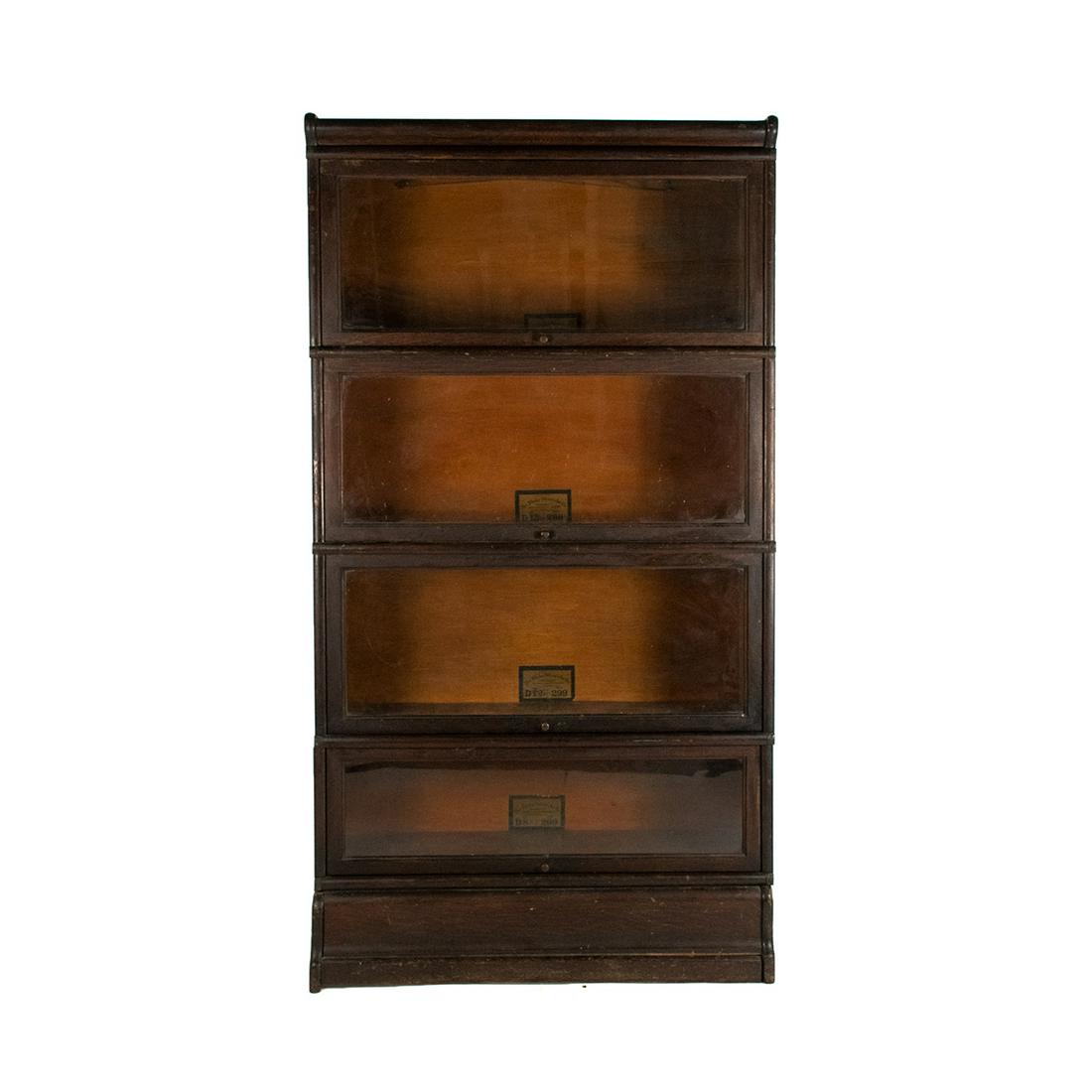 Globe-Wernicke 4 Stack Barrister Glass Front Bookcase: A Globe-Wernicke four stack barrister glass front bookcase having flip open glass fronts with metal knobs on each. Marked interior.