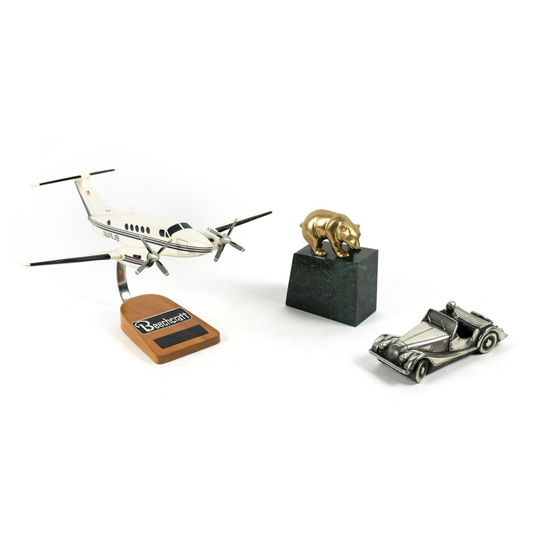 Group of 3 Model Aircraft, Marble Paperweight & Model: A grouping of 3 decorative desktop items including a Beechcraft N245JS custom aircraft model on wooden base, a cast metal model roadster car, and a Gatco brass bear atop a green marble base. Marked.