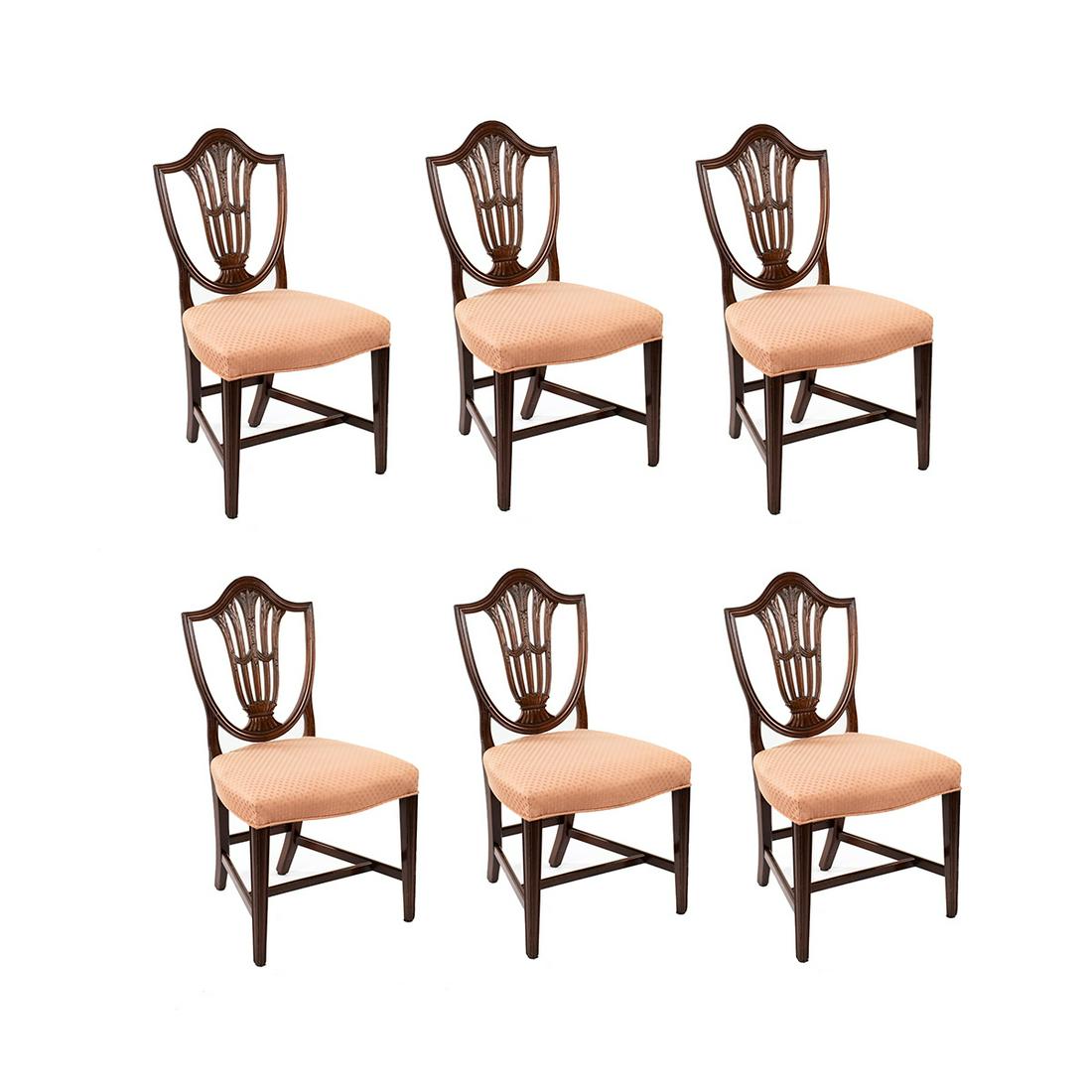 Set of Federal Mahogany Shield Back Dining Chairs: A set of six vintage Federal style dining chairs. Each chair features a pierced mahogany shield back carved with foliate and drape motifs. Each cushion is covered in pink diamond pattern upholstery. T