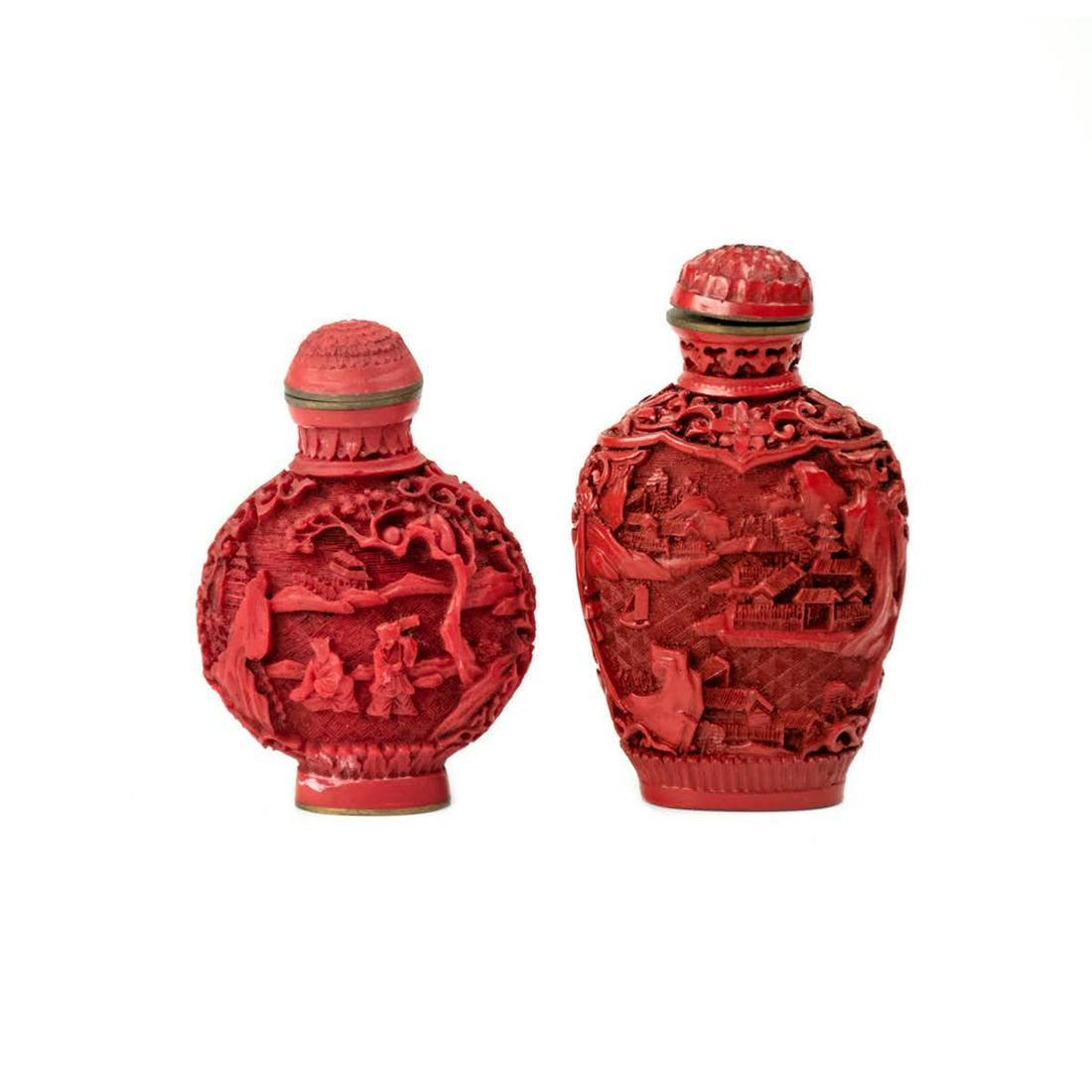 Pair of Chinese Cinnabar Carved Snuff Bottles: A pair of Chinese carved cinnabar snuff bottles having heavily carved figural scenes on the bodies and cinnabar carved toppers with spoons. Both signed on undersides.