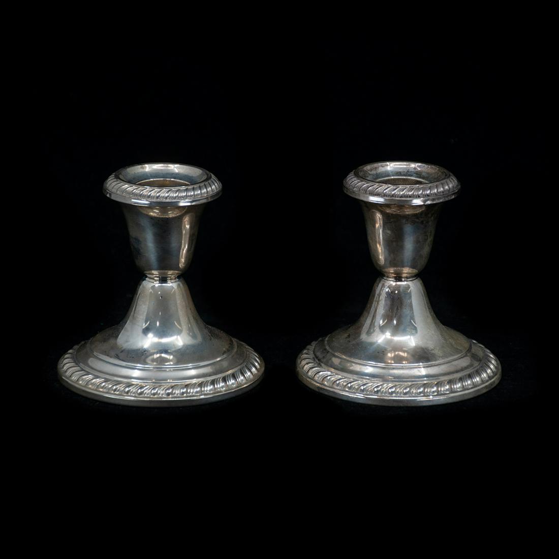 Gorham Weighted Sterling Silver Candlesticks: A pair of Gorham weighted sterling silver candlesticks. Each candlestick features an elegant form with ribbon detailing around the rim and base. Each is marked "Gorham Sterling 949 Weighted Reinforced