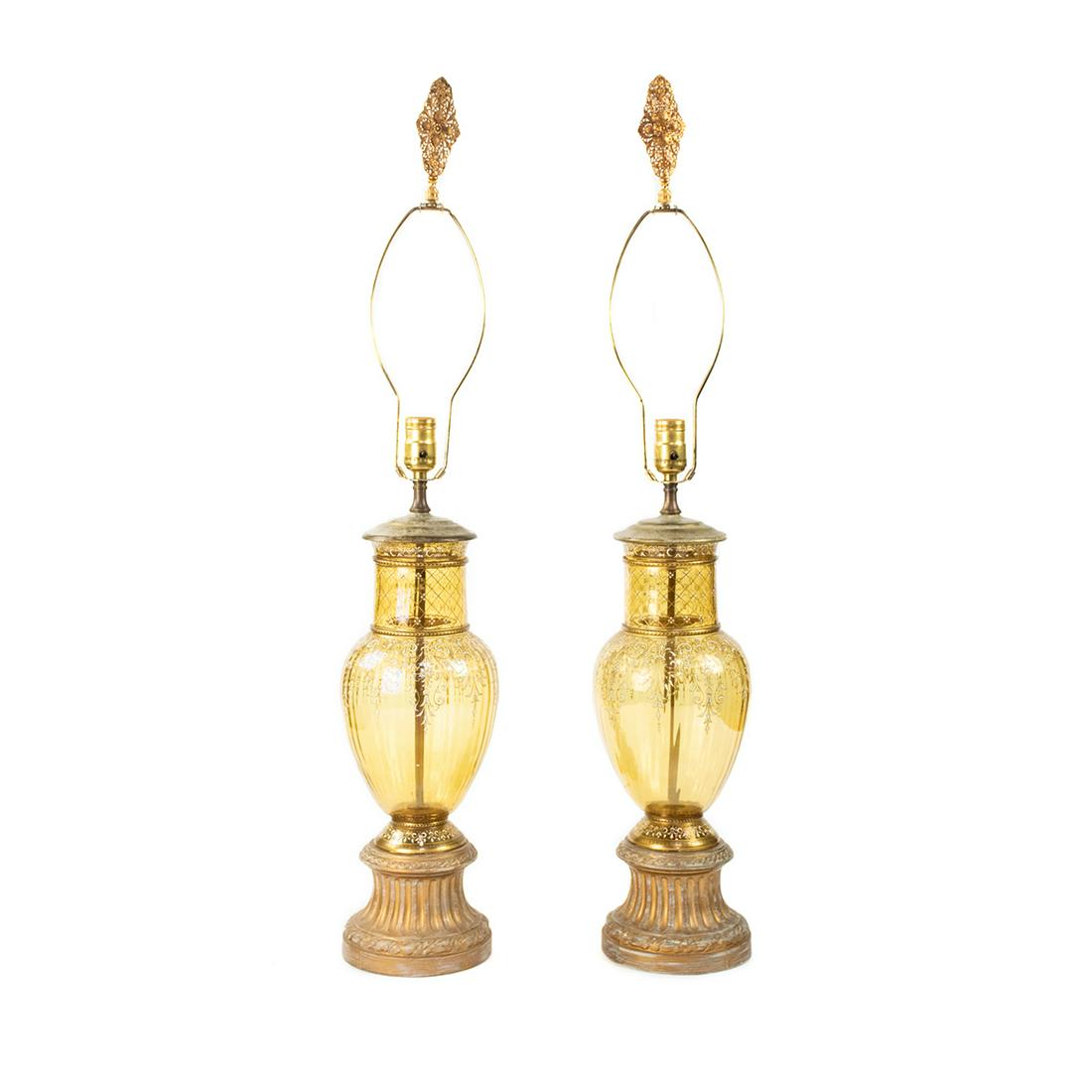 Pair of French Hand-Painted Yellow Glass Table Lamps: A pair of French hand-painted yellow glass table lamps having white line work design surrounding gold lines with brass ornate finials and carved column bases. Untested.