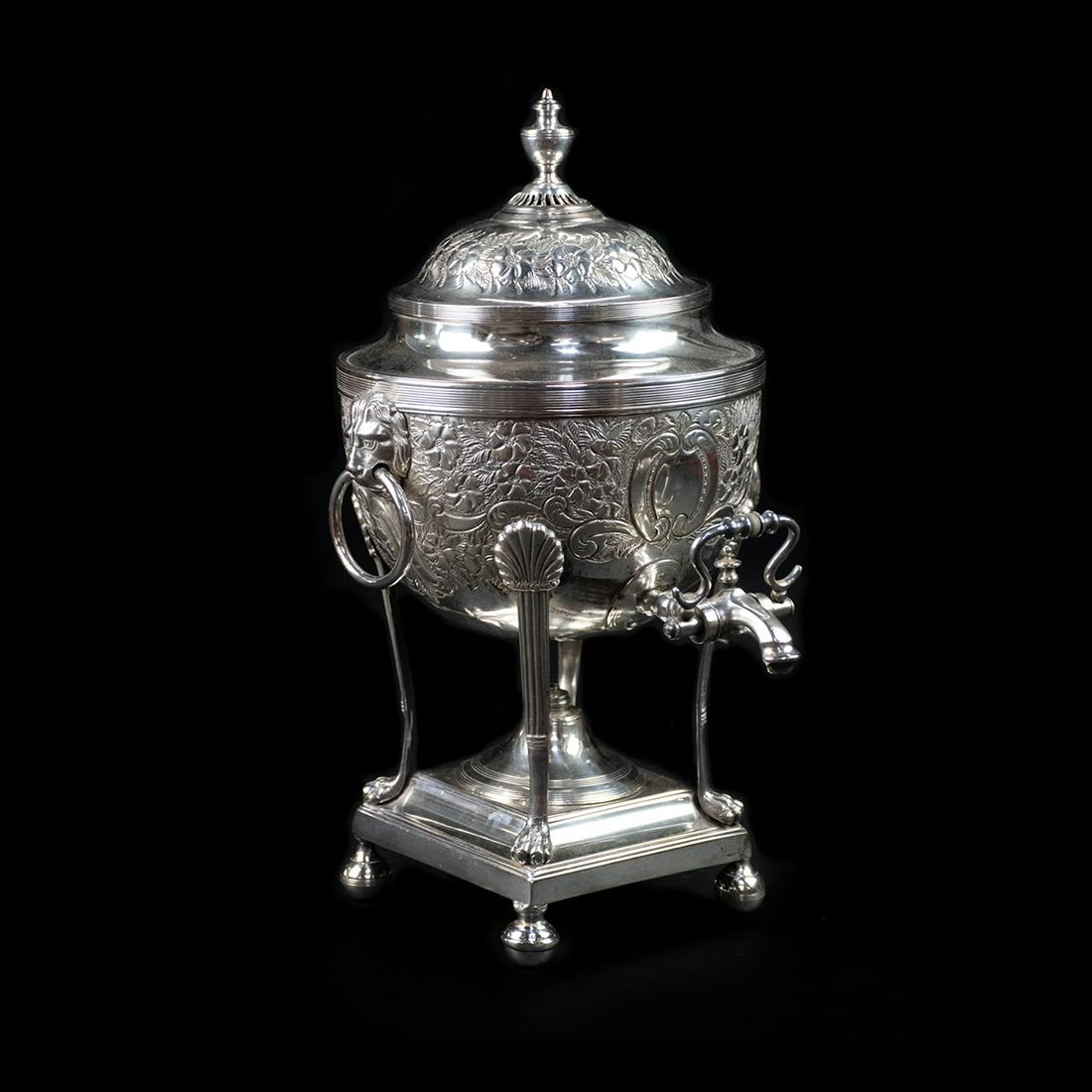 Antique George Gray Silver-Plated Samovar: An antique silver-plated samovar by George Gray. This piece features ornate raised floral designs throughout the body, a domed lid, lion head handles, lion paw feet, and a tiered pedestal base. It is