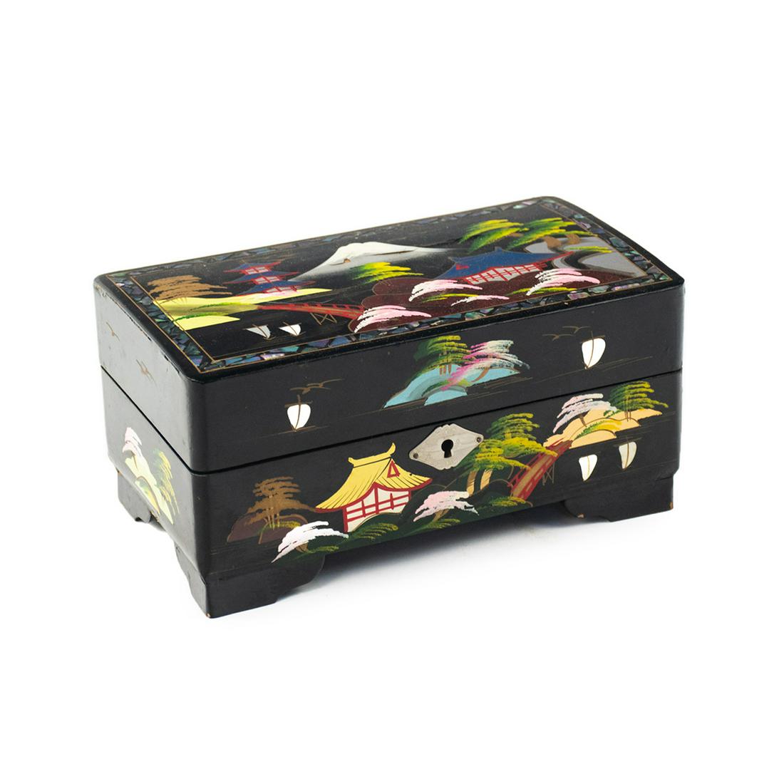 Japanese Black Lacquered Wood MOP Inlaid Music Box: A 20th century Japanese black lacquered mother-of-pearl inlaid wooden music box depicting a view of Mt. Fuji on the lid with hand painted pagoda and floral scenes throughout. The interior features a p