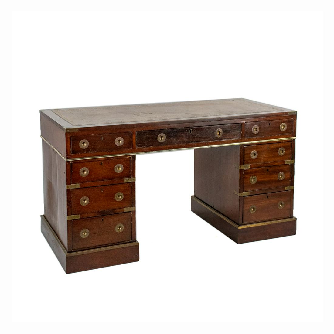 Antique Campaign Leather Top Writing Desk: An antique campaign writing desk constructed of mahogany with leather inlay tools writing surface. This piece features a leather inlay top with an eagle motif gilt border, as well as brass-bound clad 