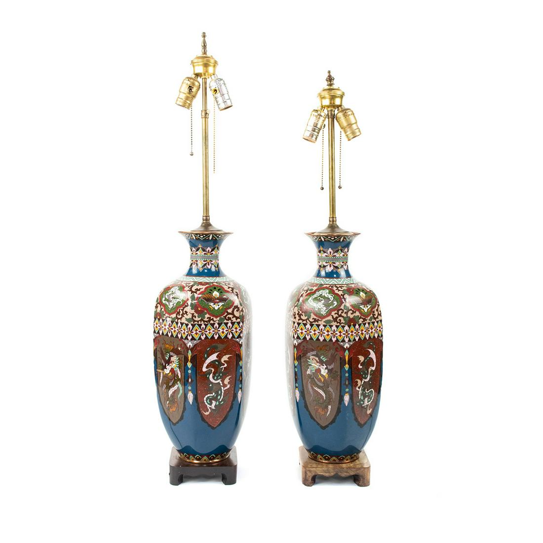 Pair of Antique Chinese Cloisonne Table Lamps: A pair of antique Chinese cloisonne enamel on copper double-light table lamps, each featuring a vase form and multi-colored dragon, phoenix, floral, foliate, and geometric motifs throughout. Each rest