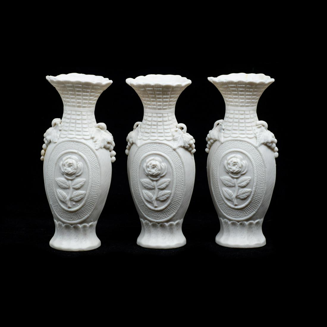 19th C. Parian Bisque Vases: A grouping of three 19th century antique parian bisque porcelain vases, each featuring a floral and grape vine motif. They are unmarked.