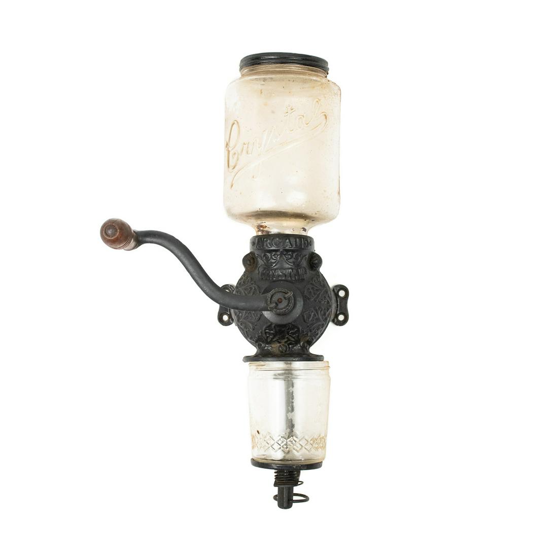 Antique Arcade Cast Iron Coffee Mill Grinder: An antique cast iron wall mounting coffee mill grinder by Arcade featuring embossed foliate designs throughout the cast iron portions, clear glass containers for the whole coffee beans and ground coff