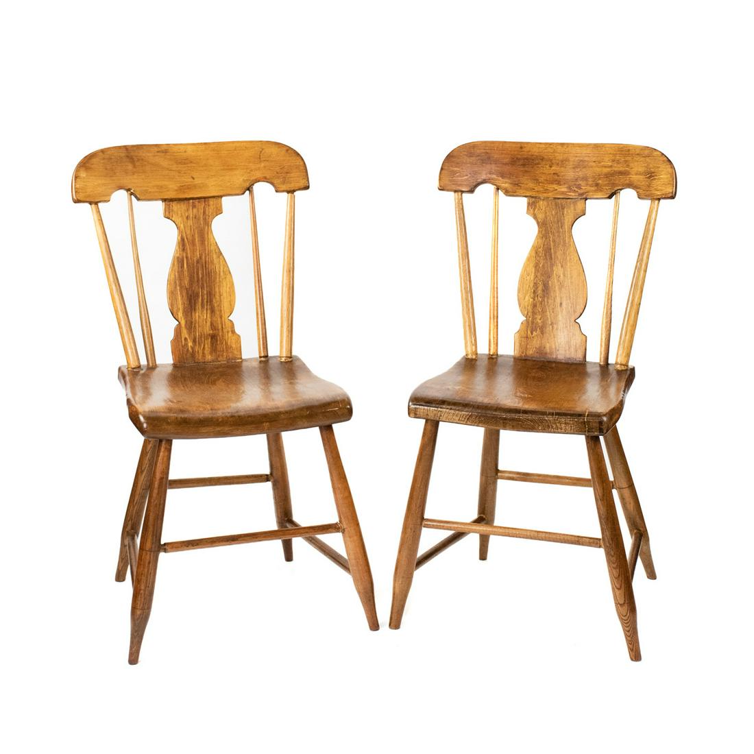 Early 19th C. Pine Windsor Splat-Back Chairs: A pair of early 19th century antique pine Windsor chairs, each featuring a fiddle splat-back flanked by two spindles on either side and completed with a rounded crest rail. Each rests atop tapered spl