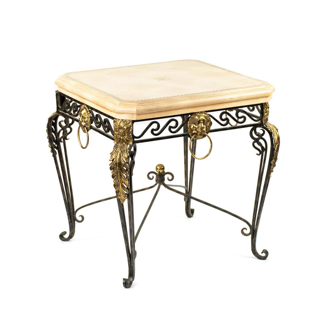 Maitland Smith Neoclassical Style End Table: A contemporary Neoclassical style end table by Maitland Smith featuring an antiqued beige faux leather resin table top, which rests atop a black wrought iron base decorated with brass lion head ring h