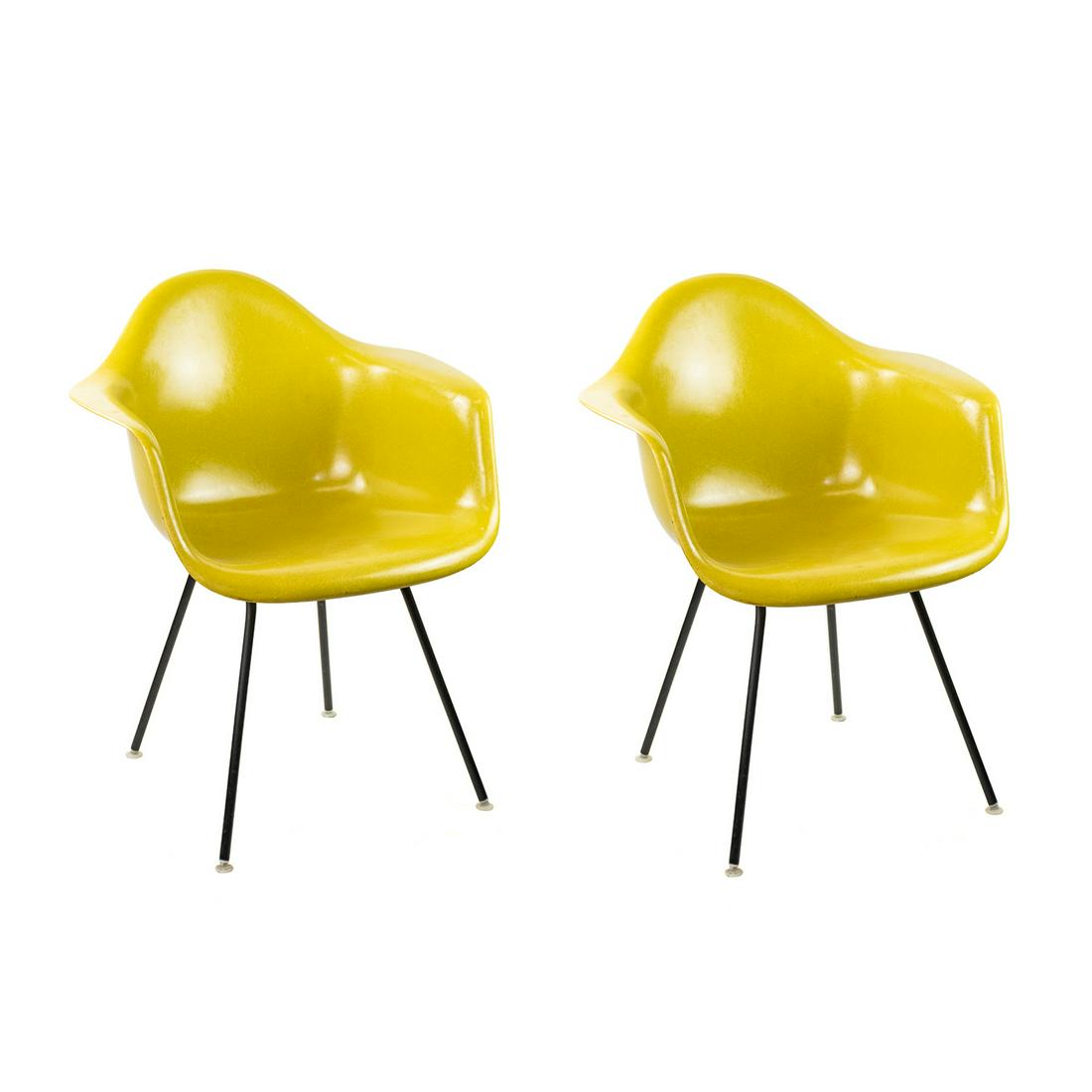 Herman Miller Eames Fiberglass Lemon Shell Chairs: A pair of vintage Mid-Century Modern Herman Miller Eames lemon yellow fiberglass shell chairs raised atop steel tubular legs completed with a black finish. Each is marked on the underside.