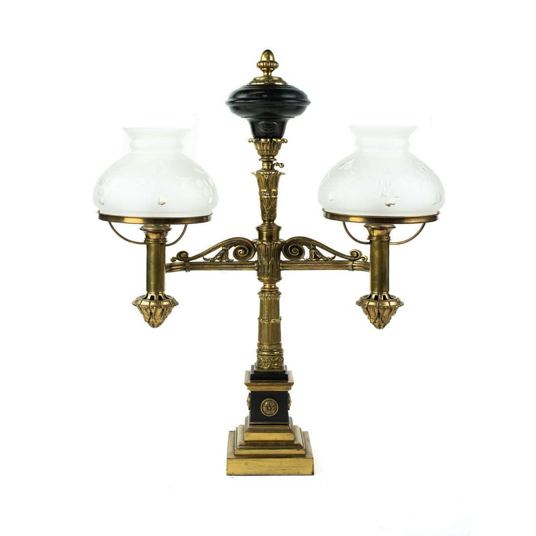Antique Cornelius & Co. Argand Double-Light Lamp: An antique Argand style brass table lamp by Cornelius & Co. of Philadelphia. This piece features a column form center decorated with embossed acanthus leaf motifs and is topped with a black painted oi