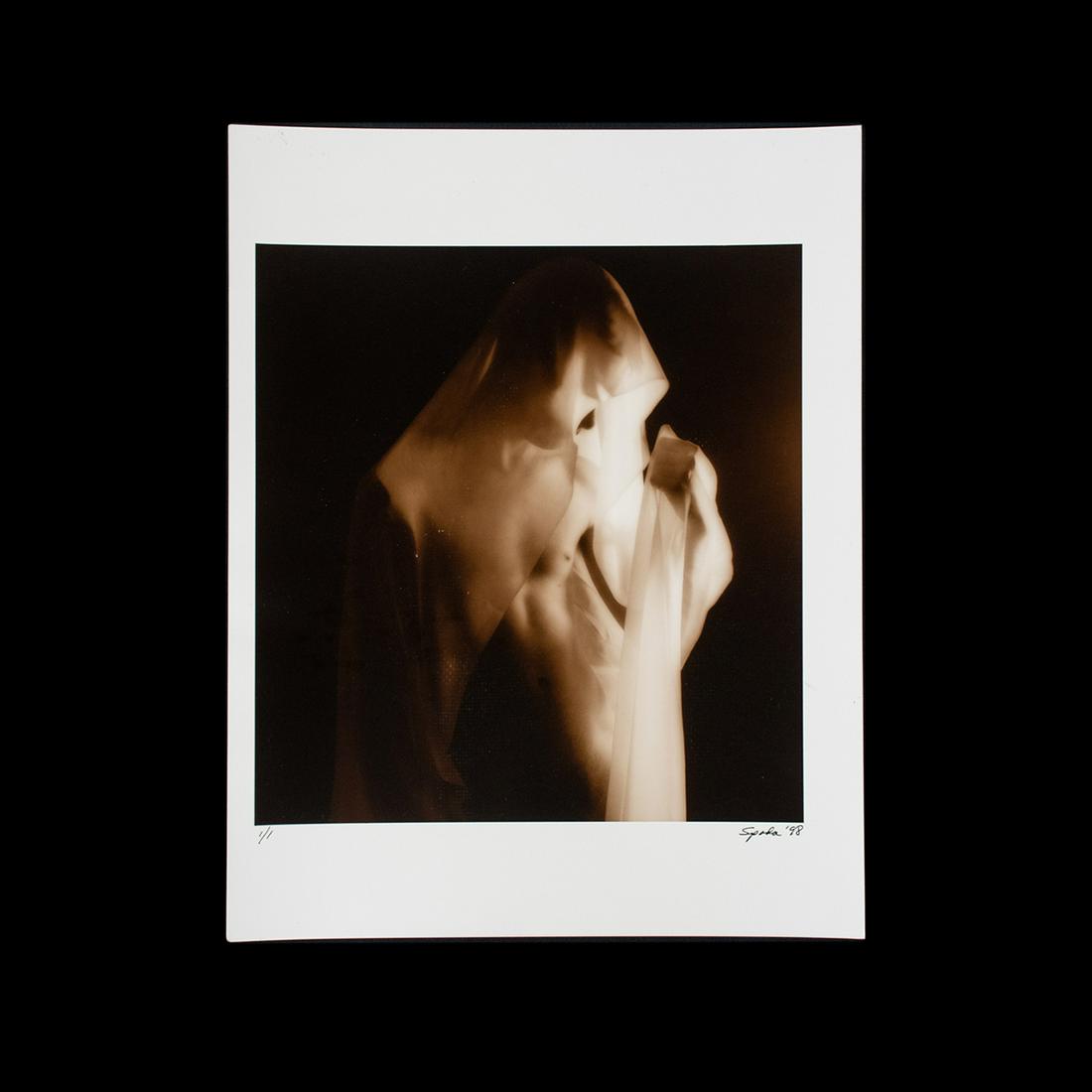 James Spada Signed Sepia Photograph: A vintage sepia photograph by James Spada circa 1998. This work features a nude male subject draped in semi-opaque white cloth. It is signed on the lower right and dated "98". It is unframed, but has 