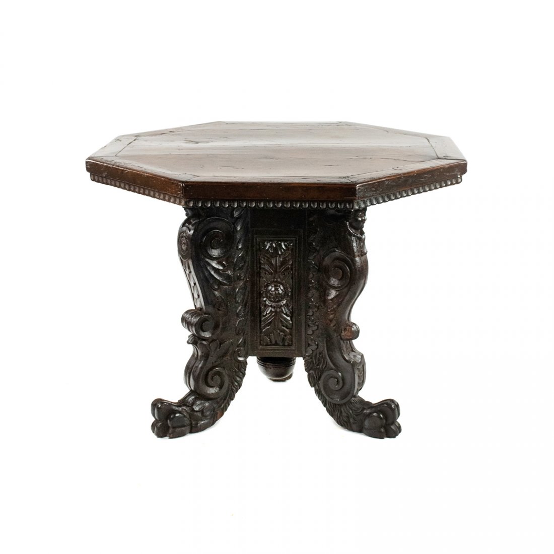 Antique Italian Renaissance Carved Octagonal Table: A 17th century Italian Renaissance period carved walnut octagonal center table have plank wooden top above a tripartite base with female busts on each leg with sides carved in leaf foliage and carved