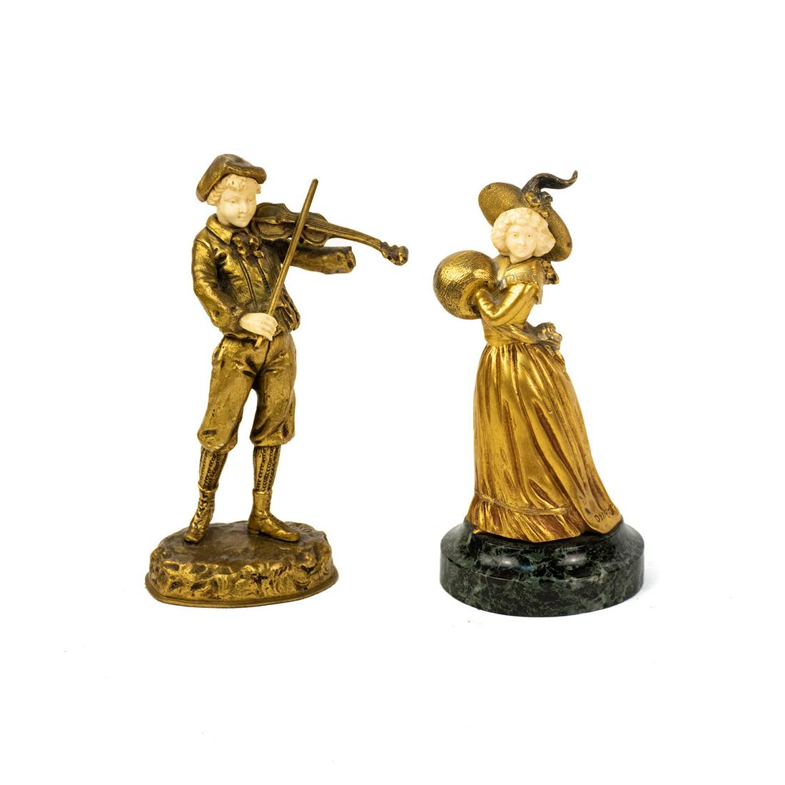 Georges Omerth and Ostreth Signed Bronze Sculptures: A grouping of two vintage gilt bronze and bone sculptures, including a sculpture of a woman atop a green marble base by Georges Omerth and a sculpture of a boy playing violin by Ostreth. Each is signe