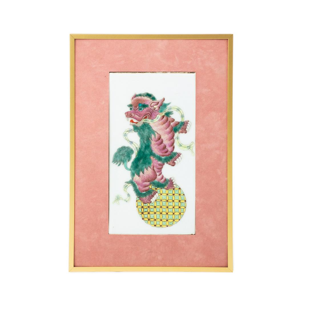 Northern Chinese Lion Ball Shizi Qiu Porcelain Tile: Antique Chinese Lion Ball Shizi Qiu painted porcelain tile plaque depicting a Peking lion or shizi with a round ball design at the feet. Presented in a gold metal frame with pink mat. Unsigned.