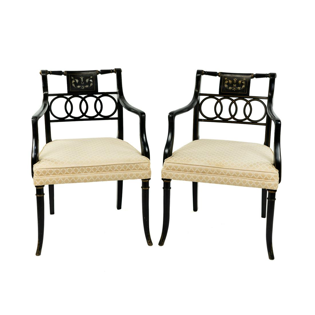 Pair Regency Style Ring Back Black Lacquered Armchairs: A pair of Regency style ring back black lacquer armchairs having carved interlocking ring back splat and gold painted accents with painted scrollwork panel and upholstered. Seat height: 17.5" SHIPPING