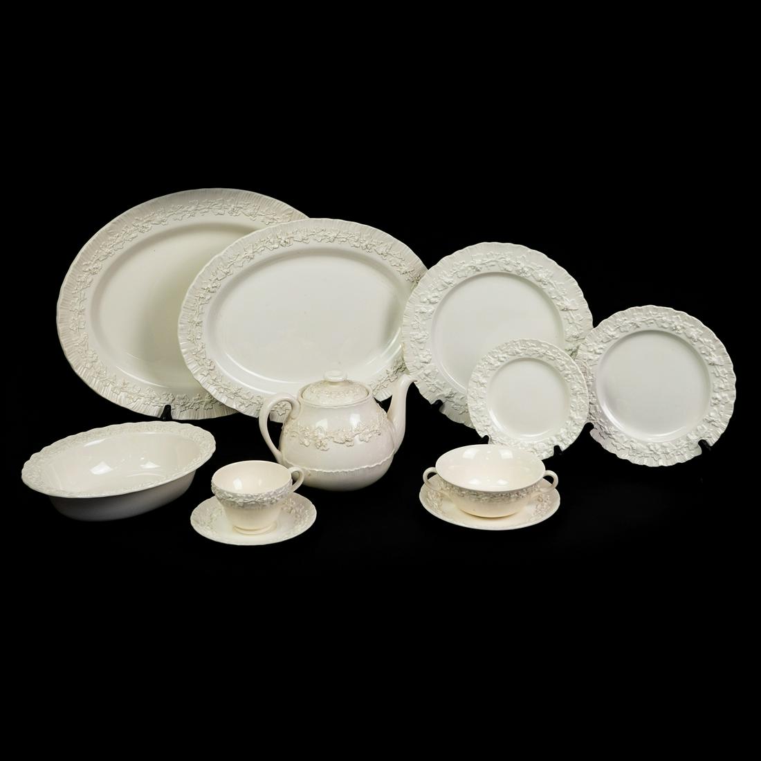 Wedgwood Embossed Queensware 131 pcs Etruria & Barlaston: A Wedgwood "Embossed Queensware" china set of 131 pieces. Each piece features a cream tone glaze with a glossy finish and a raised floral pattern around the edges. All the plates have a unique shell s