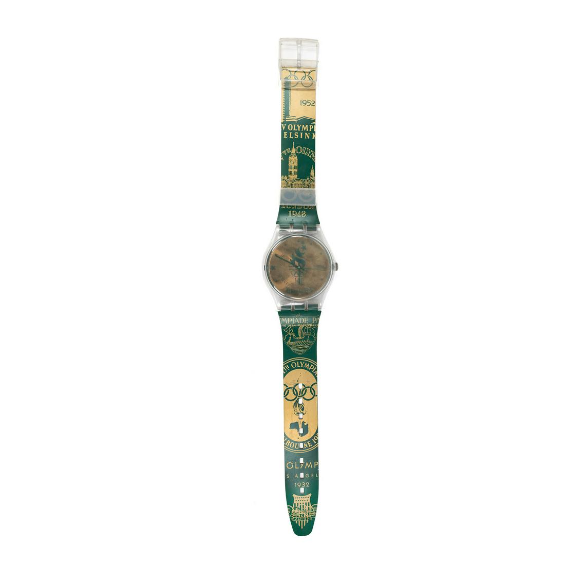 Swatch Maxi Atlanta Olympics 1996 Watch Wall Clock: A Swatch 'Maxi' oversized watch wall clock circa 1994 having an 'Atlanta 1996' copper toned plastic face with plastic hands and a clear plastic cover and 2 attaching bands that feature images and date