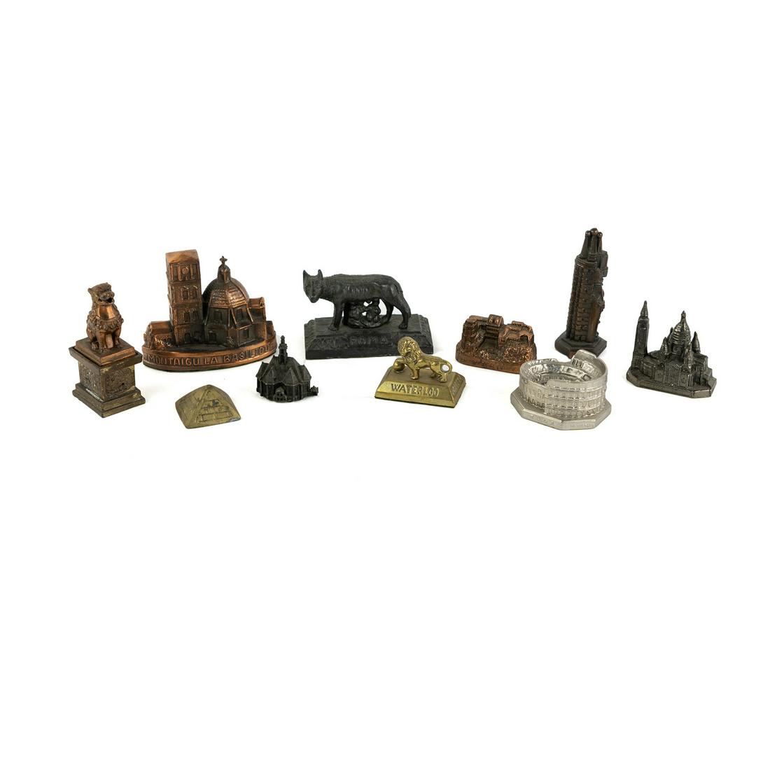 (10) Metal Souvenir Miniature Buildings and Monuments: A group of metal souvenir miniature buildings and monuments including Waterloo Lion Mound Monument, Montaigu La Basilique, Capitoline Wolf 'Roma', The Colosseum, a Chinese Foo dog, etc.