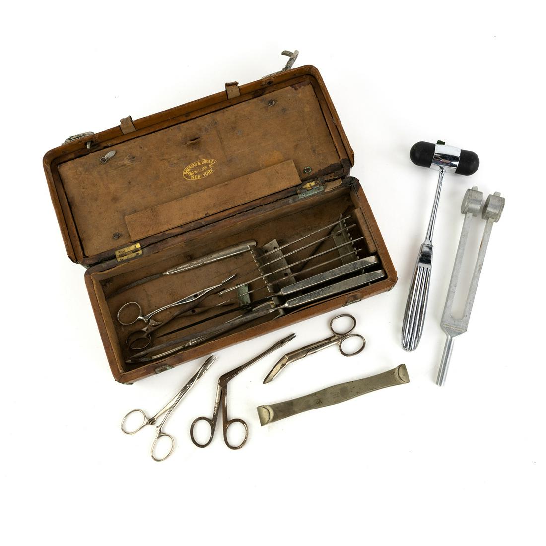 19th C Shepard & Dudley Medical Surgical Tool Set: A late 19th C Post-Civil War era Shepard & Dudley medical surgical kit including scalpels, reflex hammer, tuning fork, bandage scissors, retractor, etc. in a fitted leather box with slotted metal hold