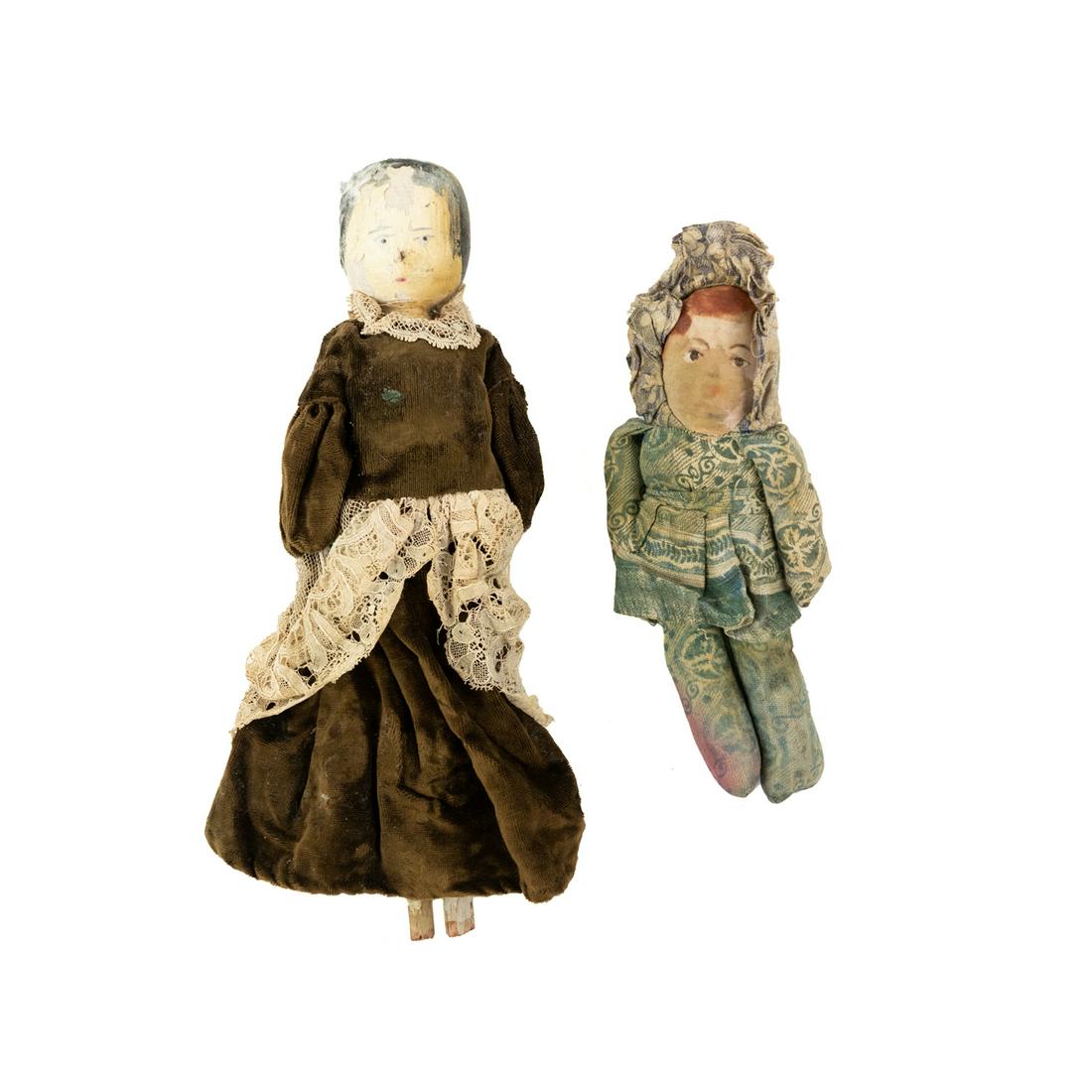 Antique Hand Painted Wood and Cloth Dolls: A group of 2 antique handmade dolls including a hand-painted wood doll adorned with satin bloomers and a velvet and lace dress having hand-painted face detail, a stuffed cloth doll with a patterned fa