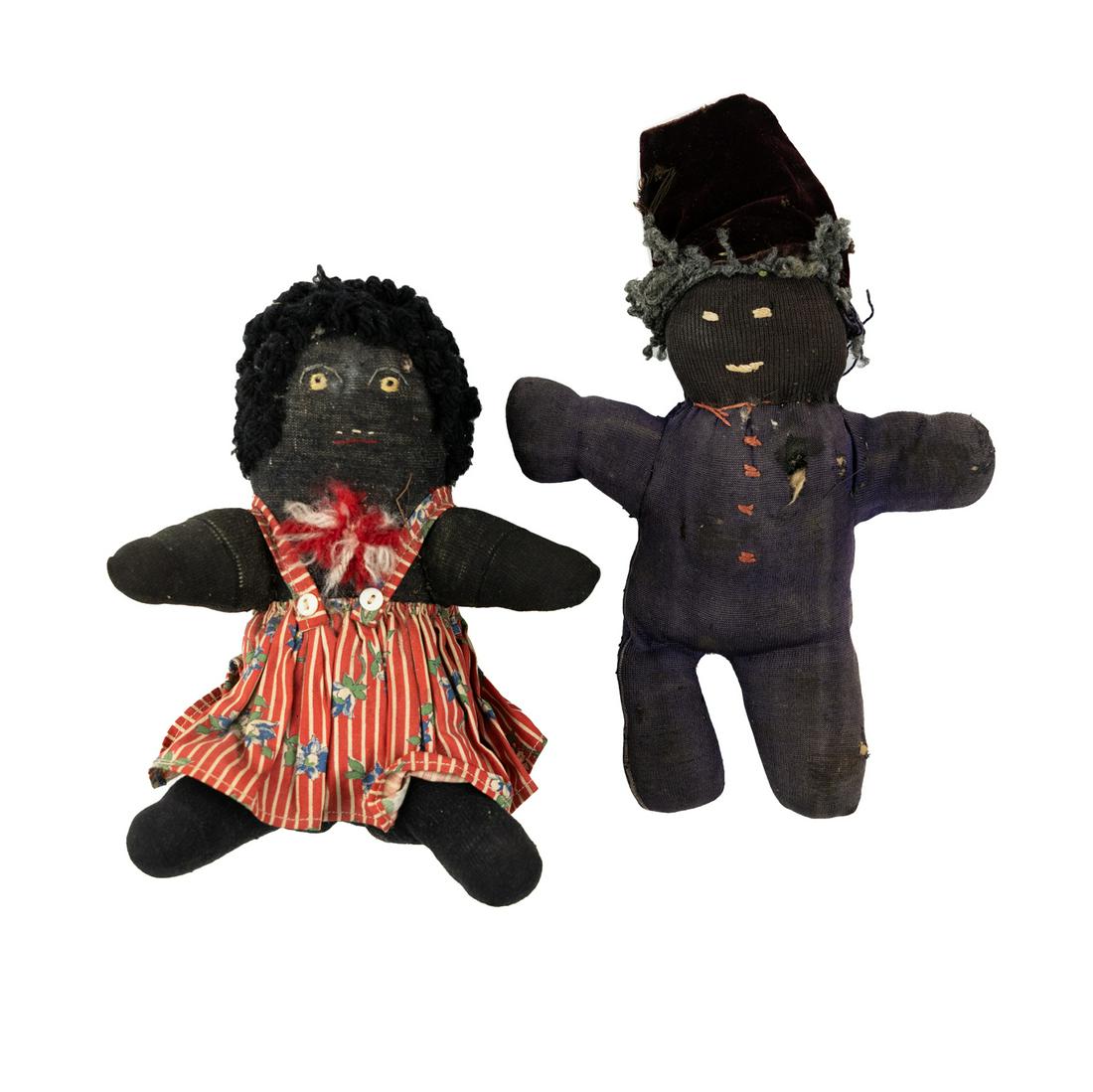 Antique Black Americana Handmade Cloth Dolls: A group of 2 antique Black Americana handmade cloth dolls including a female figure adorned with a striped floral dress and yarn hair, hand-stitched embroidery face detail, and a doll having a velvet 