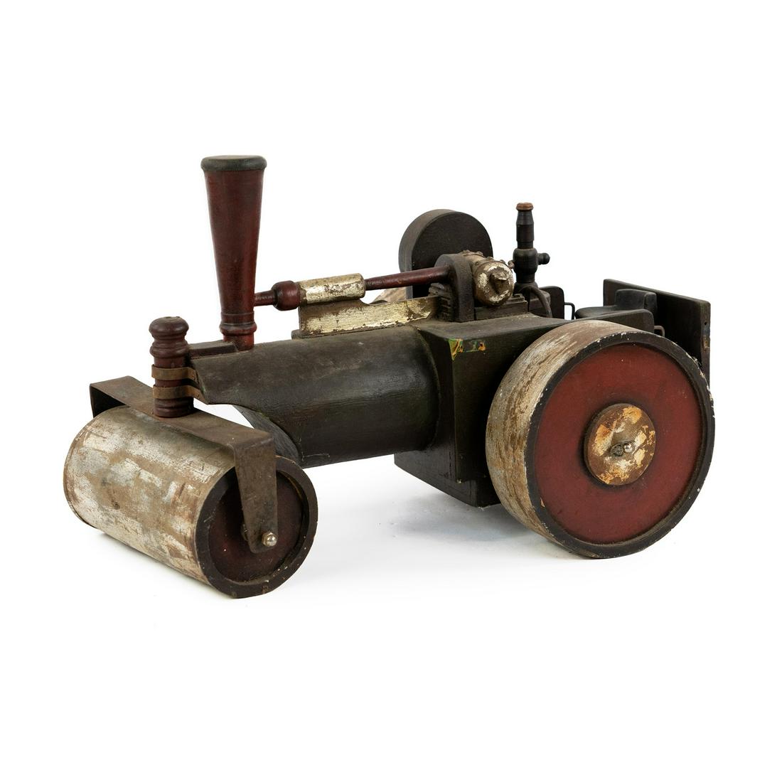 Vintage Toy Wooden Steam Roller Engine: A primitive antique toy wooden steam roller painted black with red and silver accents with rotating wheels and steering wheel. Has a chain decoration on one side and a metal hook attached to the back.
