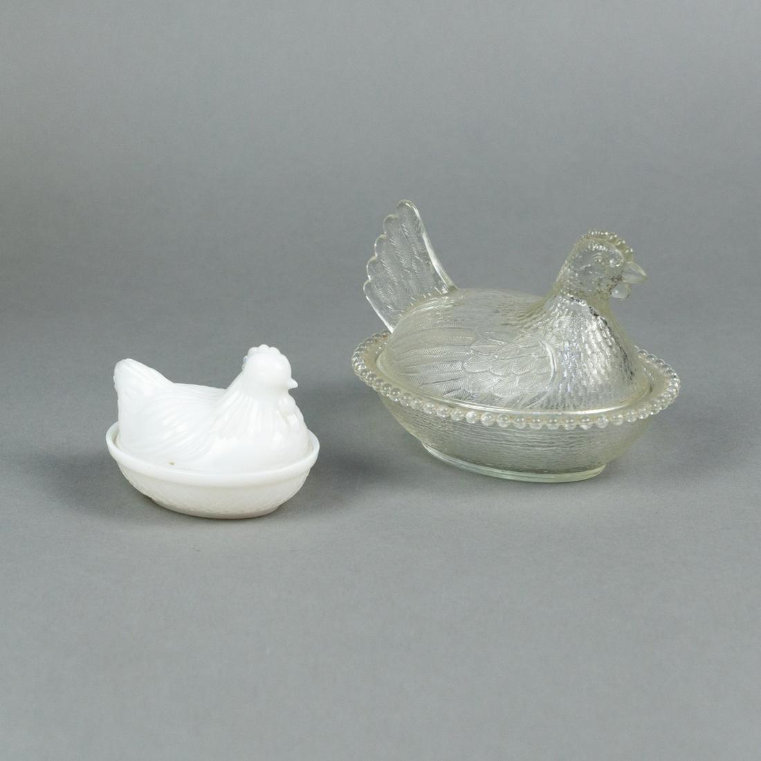 (2) Nesting Hen Glass Covered Candy Dishes: A group of 2 nesting hen glass covered candy dishes including 1 clear glass and 1 milk glass.