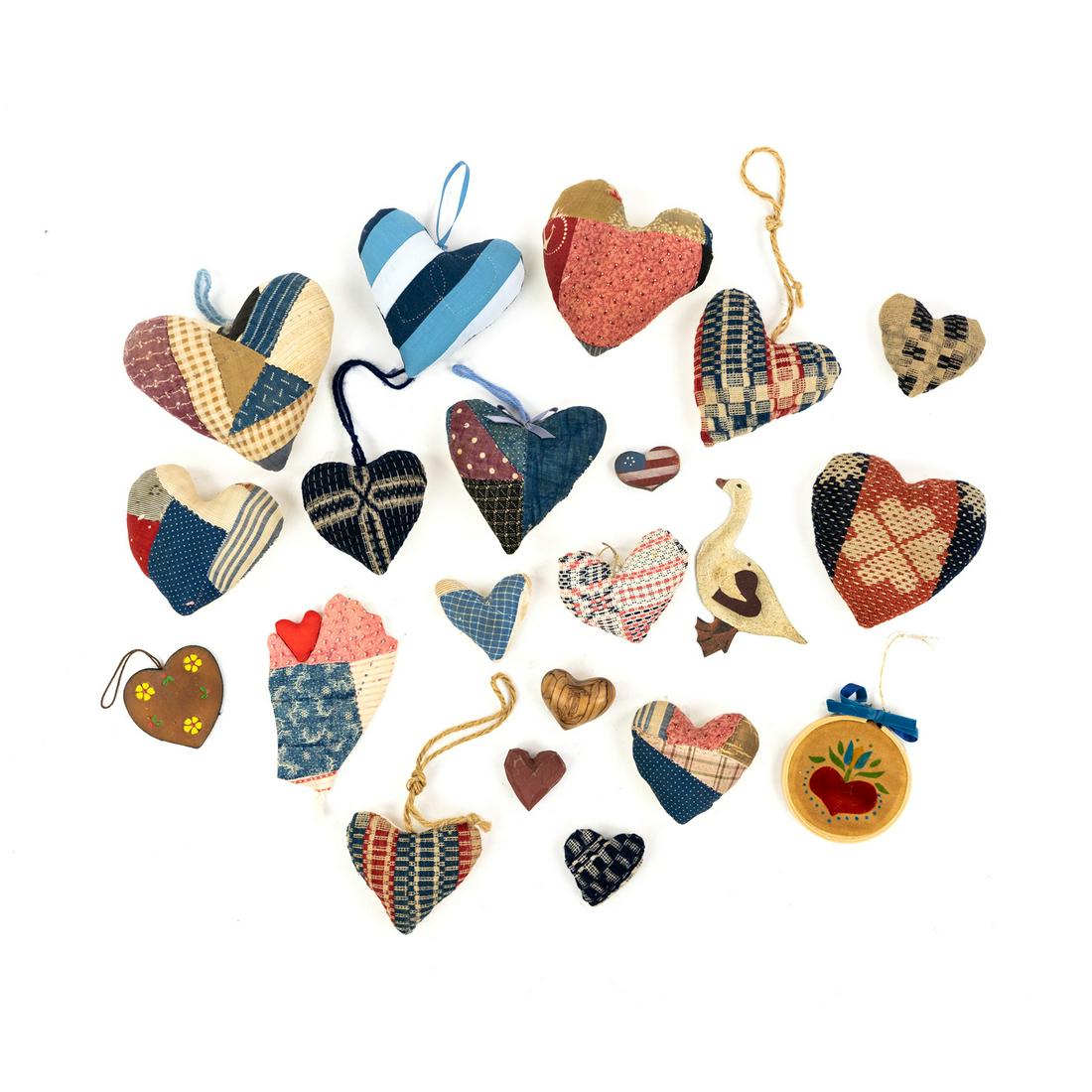 Assorted Hand-Sewn Quilt Hearts and Ornaments: A collection of assorted vintage hand-sewn and stuffed quilt hearts and ornaments with various fabric patterns including one with an early Pennsylvania hearts & stars coverlet on the front inscribed a