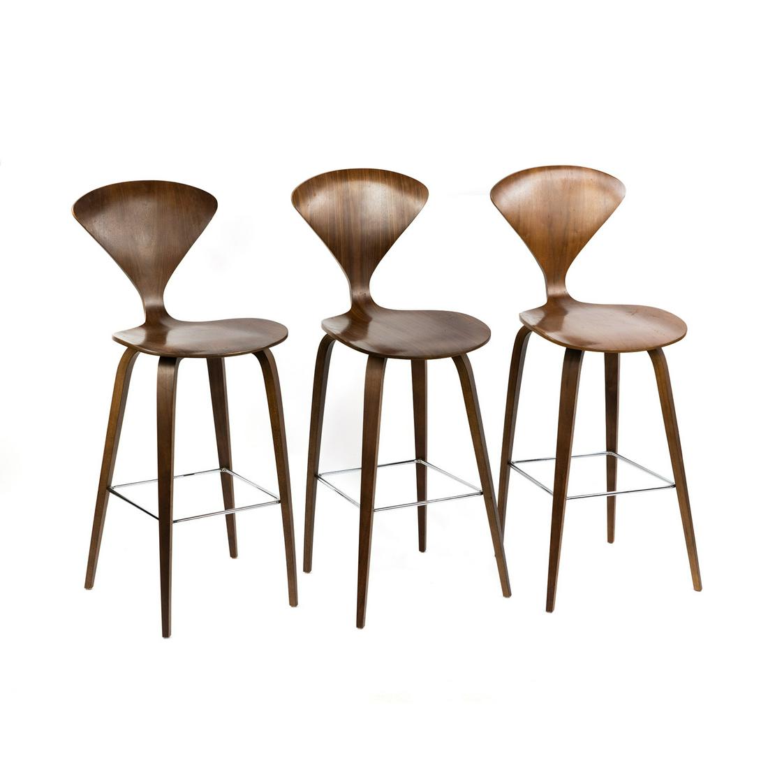 (3) Norman Cherner Plywood Bar Stools: A set of three (3) Norman Cherner design Cherner Chair Company molded plywood counter bar stools having triangular shape back chrome plated steel supports. Original sticker and serial number on unders