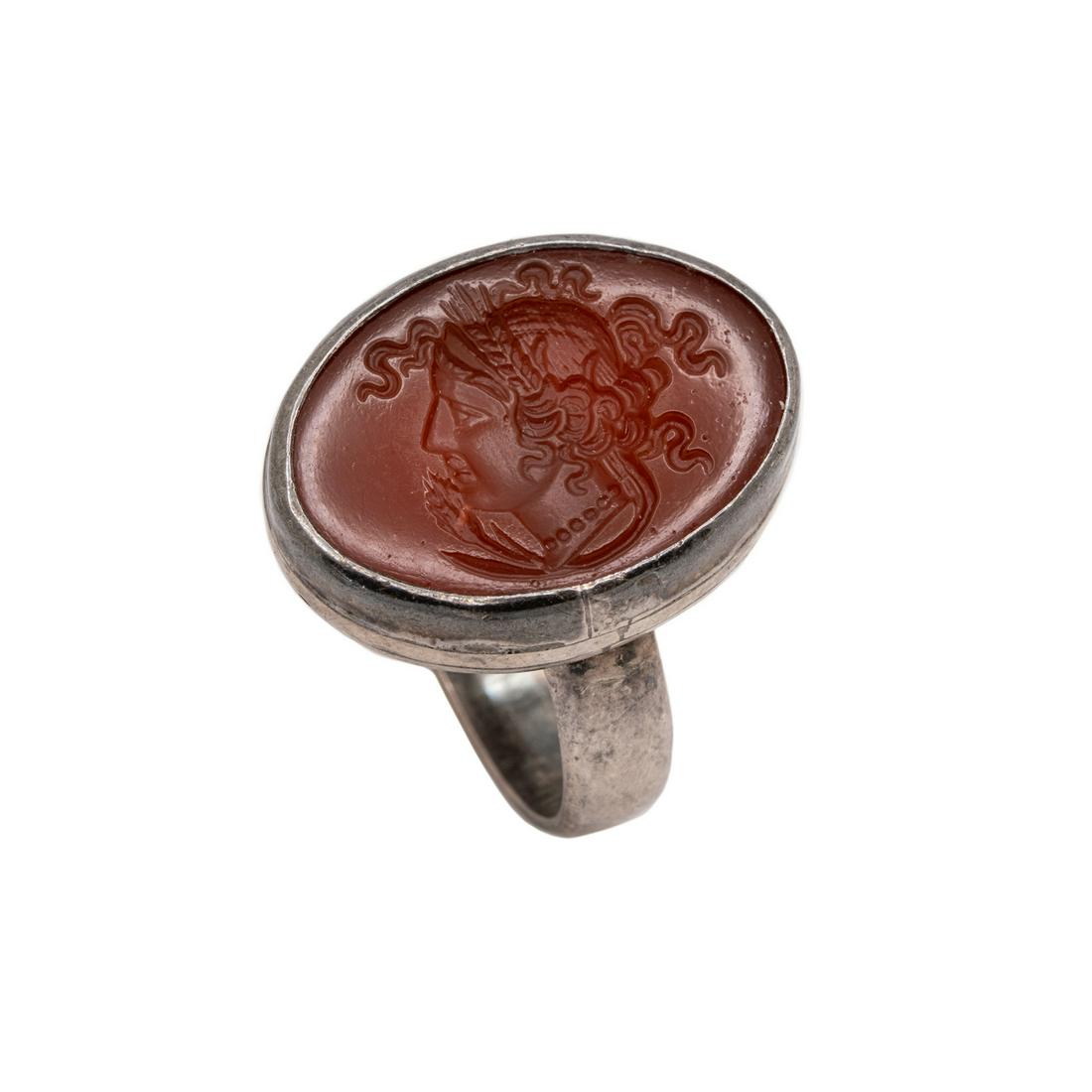 Vintage Sterling Carnealian Intaglio Ring: A vintage sterling carnealian intaglio ring having a cameo of a female, possibly Greek or Roman in nature. Stamped "sterling" on inside of band along with two additional markings. Overall weight: 0.3 