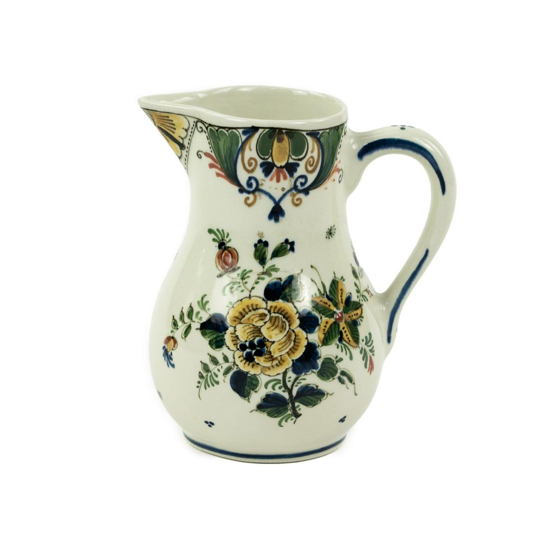 Small Delft Hand Painted Pitcher: A small Delft hand-painted pitcher having floral design with muted yellow, blue, green and rust tones. Marked and hand signed by artist on underside.