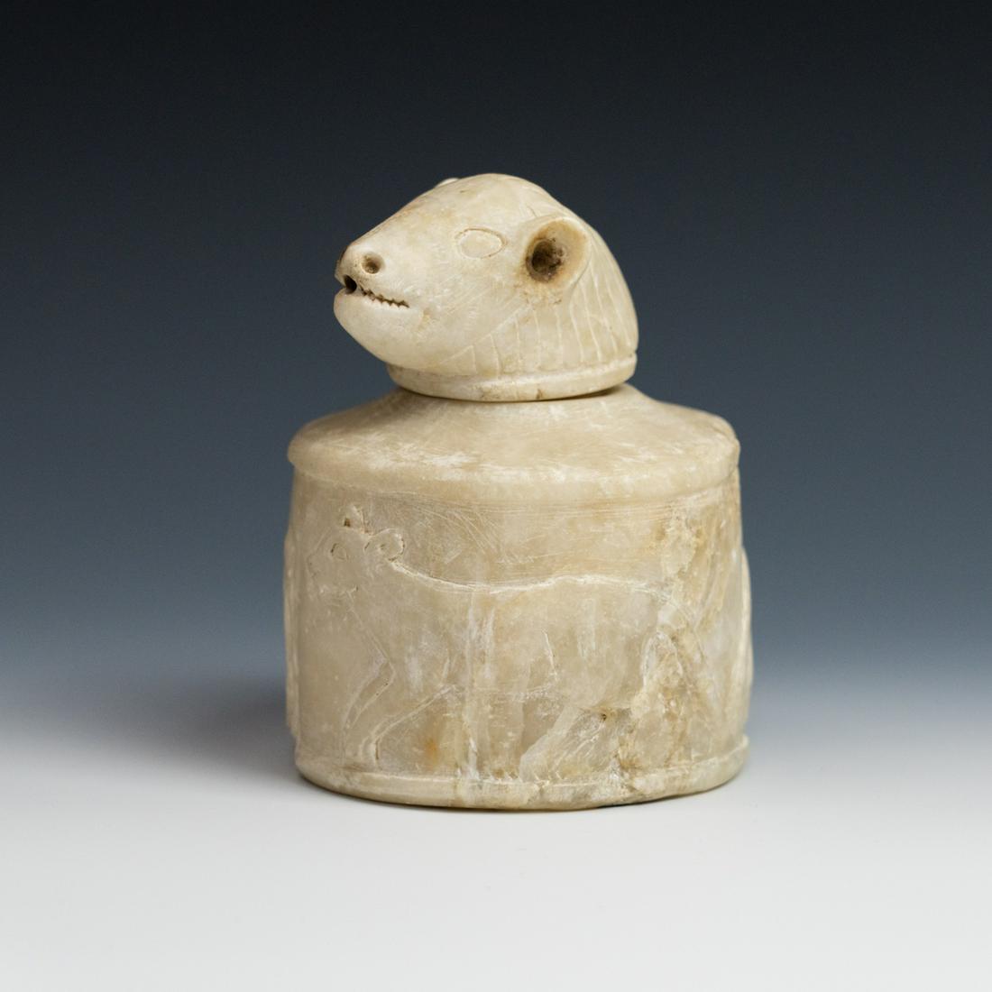 Ancient Egyptian Duamutef Canopic Jar: An Ancient Egyptian Late Saite Canopic Duamutef jackal-headed jar possibly 660-525 BC carved from travertine (Egyptian alabaster) with incised animal designs on side and removable lid carved in the sh