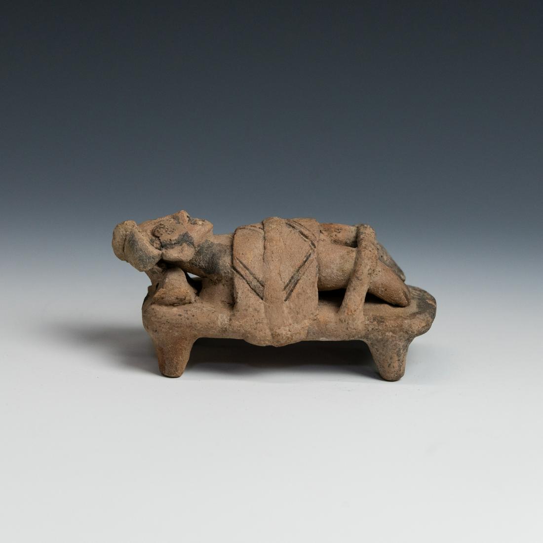 Pre-Columbian Colima Pottery Deathbed Figure: A Pre-Columbian Colima pottery deathbed figure circa 250 BC - 200 AD depicting a deceased man strapped to a bed on display before internment. Provenance: purchased from NY dealerâ€”The Lands Beyo